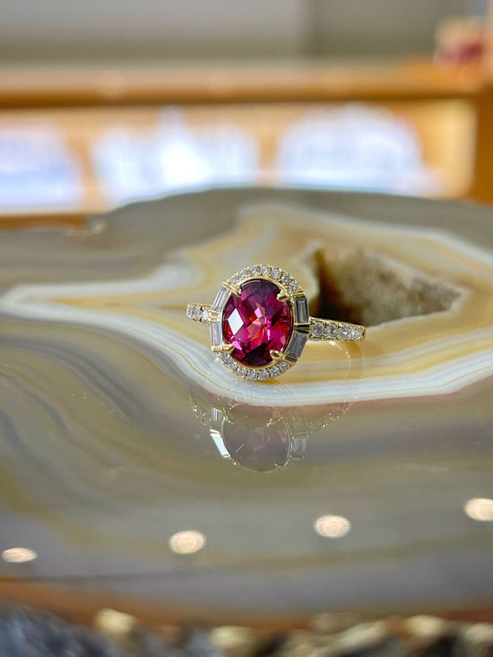 Photo of Stanton Color Rhodolite Garnet Ring in a decorative scene, designed by , available at Plumb Gold & Plumb Silver