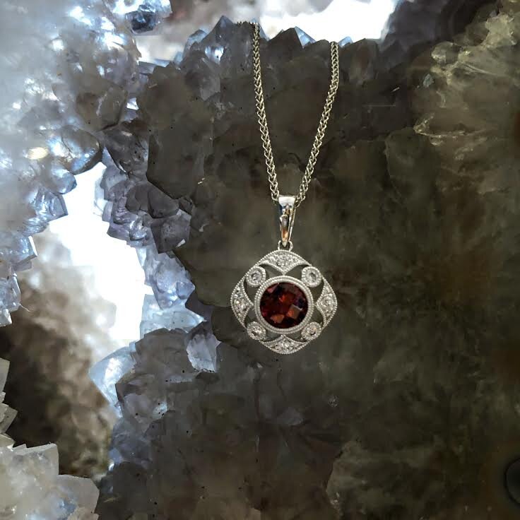 Photo of Stanton Color Vintage-Inspired Rhodolite Garnet Pendant in a decorative scene, designed by , available at Plumb Gold & Plumb Silver