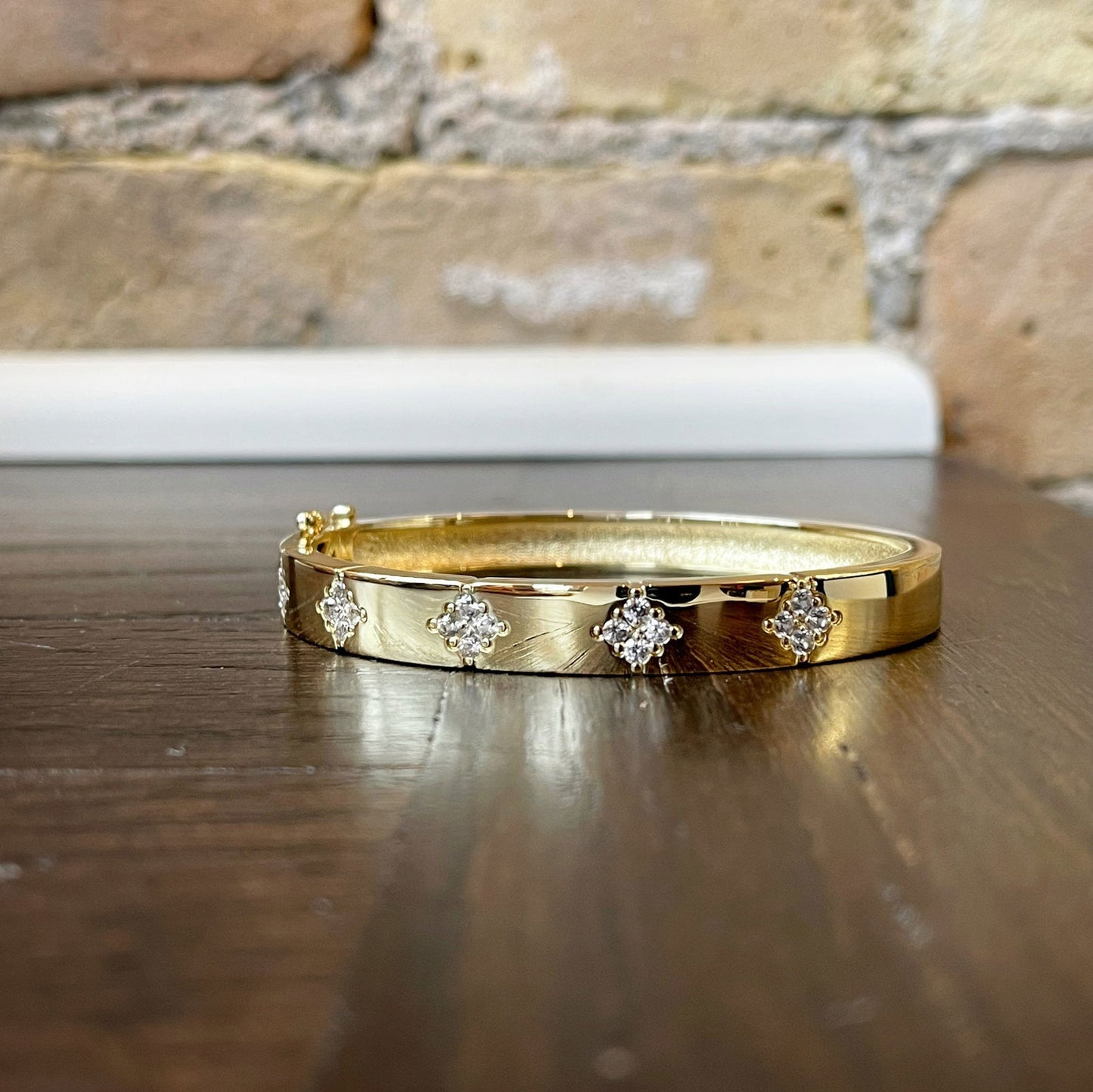 Photo of Starburst Bangle in a decorative scene, designed by , available at Plumb Gold & Plumb Silver