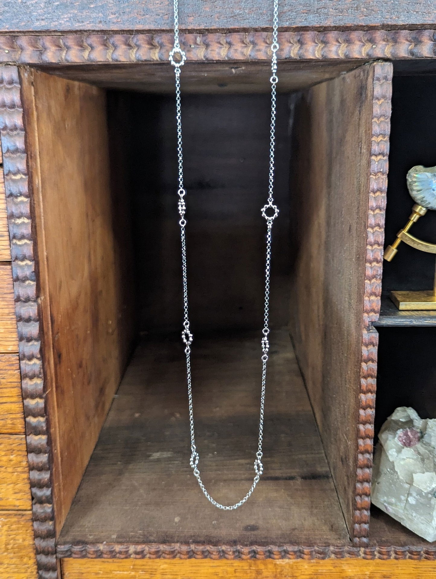 Photo of Station Necklace in a decorative scene, designed by , available at Plumb Gold & Plumb Silver