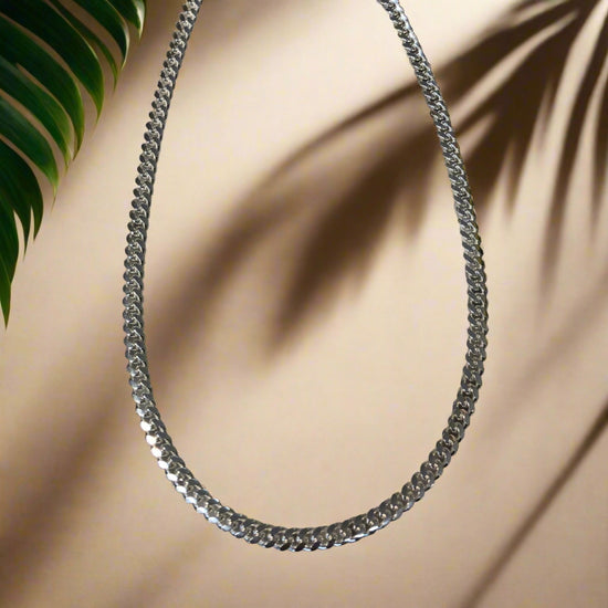 Photo of Sterling Silver 6.4mm Curb Link Diamond Cut Chain in a decorative scene, designed by , available at Plumb Gold & Plumb Silver