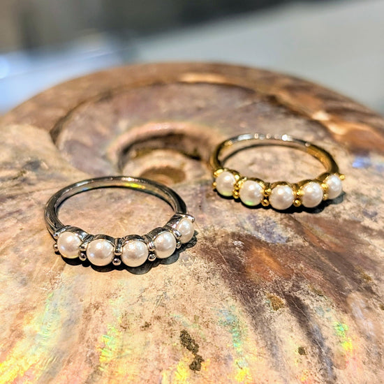 Photo of Sterling Silver Simulated Pearl Stackable Ring in a decorative scene, designed by , available at Plumb Gold & Plumb Silver