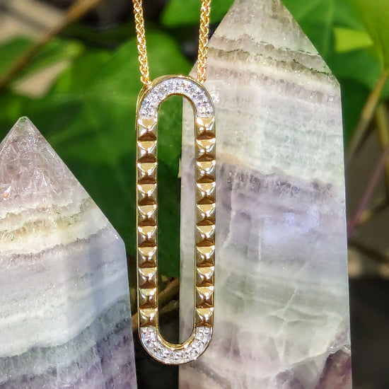 Photo of Studded Oval Pendant in a decorative scene, designed by , available at Plumb Gold & Plumb Silver