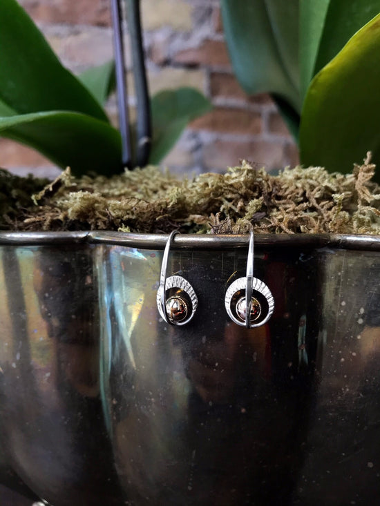 Photo of "Sunrise" Earrings in a decorative scene, designed by , available at Plumb Gold & Plumb Silver