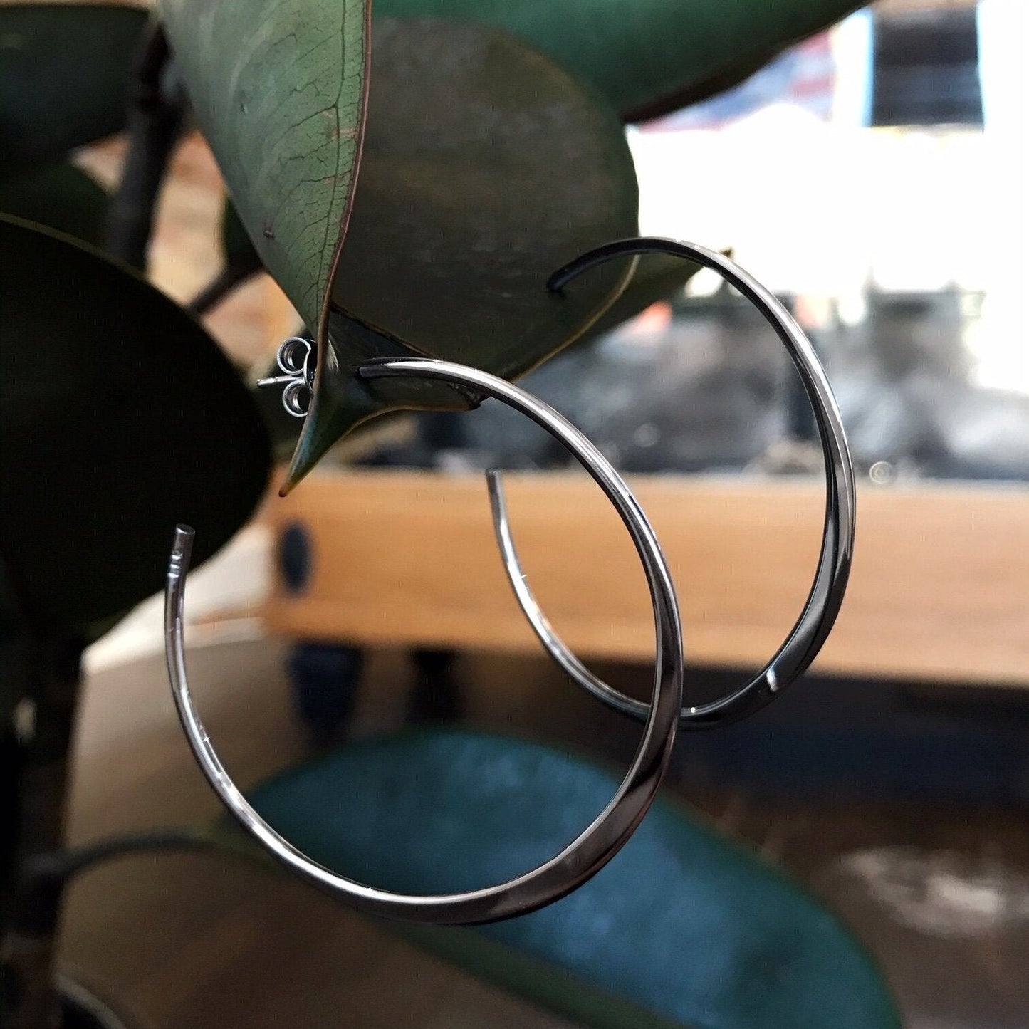 Photo of Tapered Hoops in a decorative scene, designed by , available at Plumb Gold & Plumb Silver