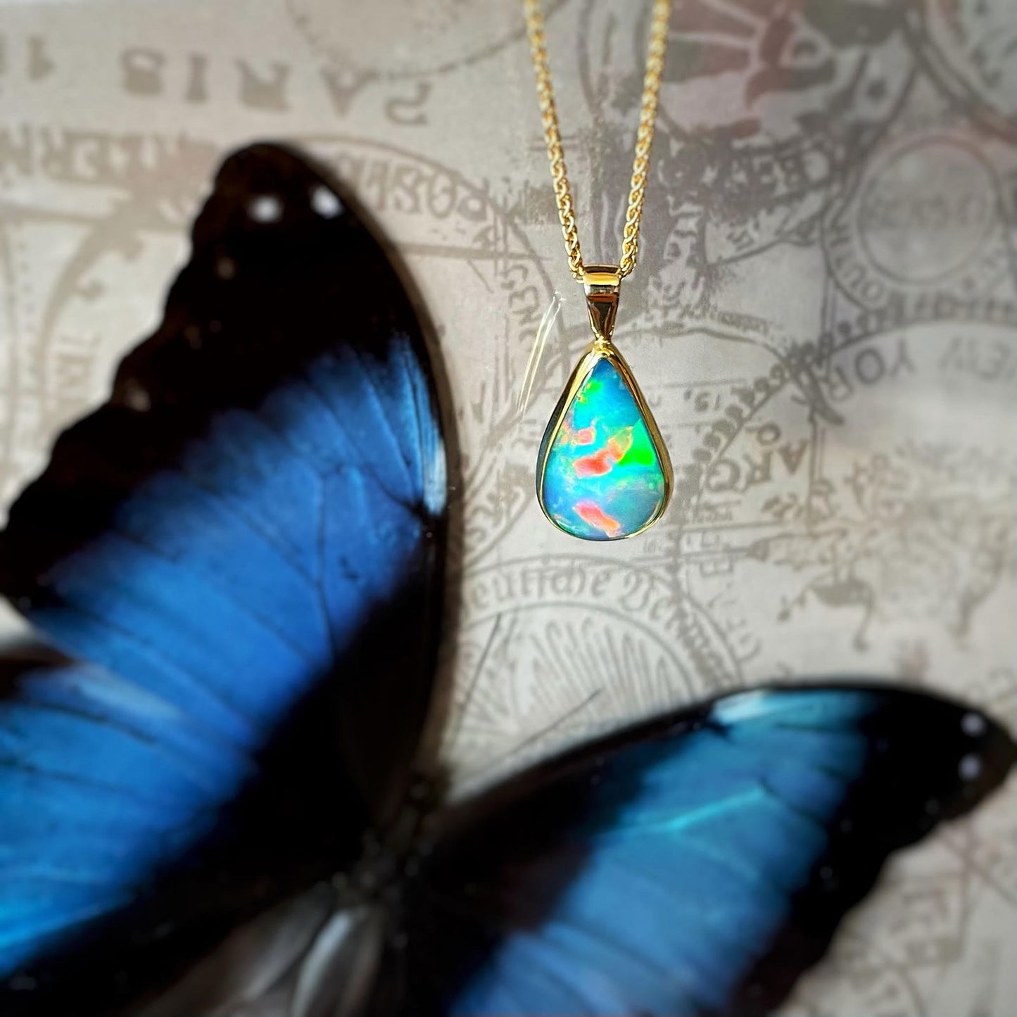 Photo of Teardrop Ethiopian Opal Pendant in a decorative scene, designed by , available at Plumb Gold & Plumb Silver