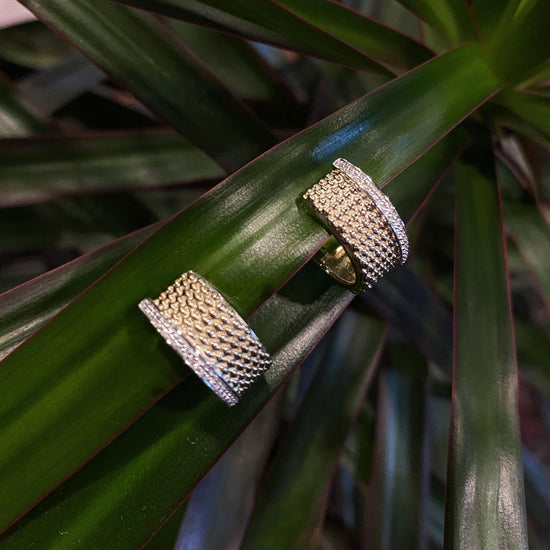 Photo of Textured Huggies with White Sapphire Accents in a decorative scene, designed by , available at Plumb Gold & Plumb Silver