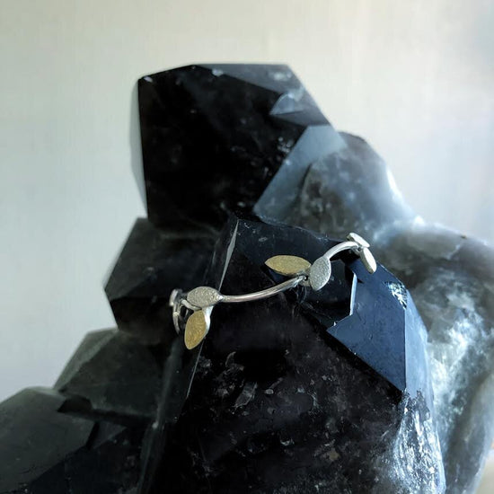 Photo of Textured Leaf Bracelet in a decorative scene, designed by , available at Plumb Gold & Plumb Silver
