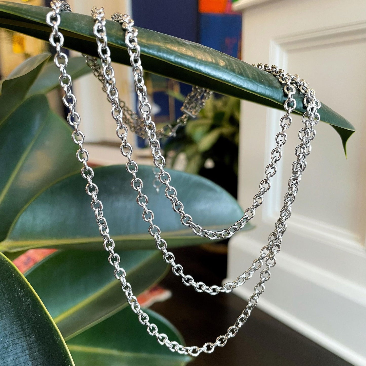 Photo of Three Strand Chain Necklace in a decorative scene, designed by , available at Plumb Gold & Plumb Silver