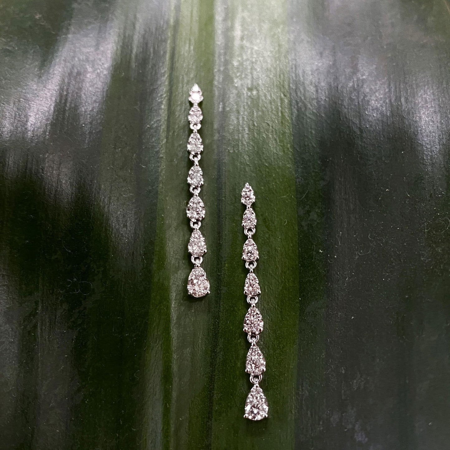 Photo of Tiered Diamond Dangle Earrings in a decorative scene, designed by , available at Plumb Gold & Plumb Silver