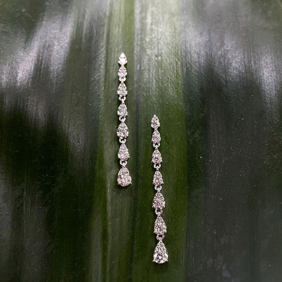 Photo of Tiered Diamond Dangle Earrings in a decorative scene, designed by , available at Plumb Gold & Plumb Silver