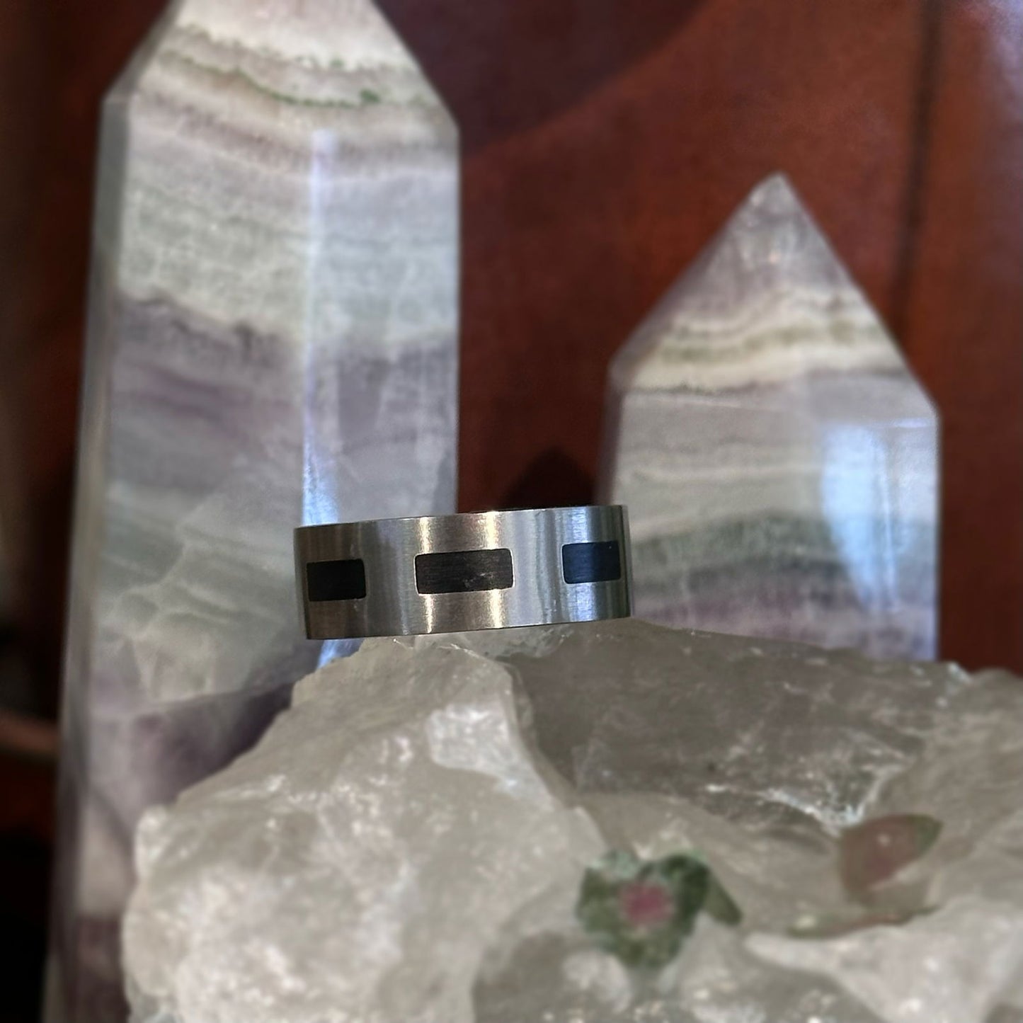 Photo of Titanium Black Accent Band in a decorative scene, designed by , available at Plumb Gold & Plumb Silver