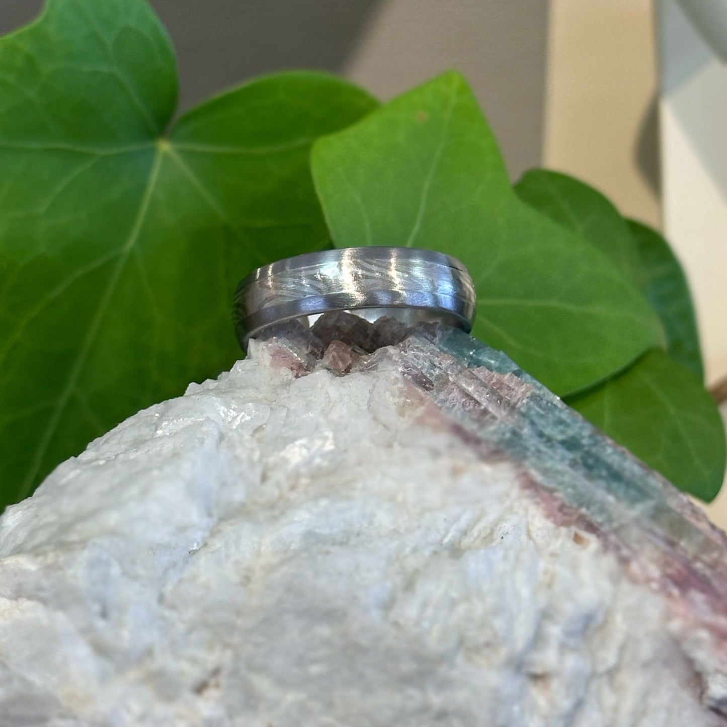 Photo of Titanium Sterling Silver Mokume Band in a decorative scene, designed by , available at Plumb Gold & Plumb Silver