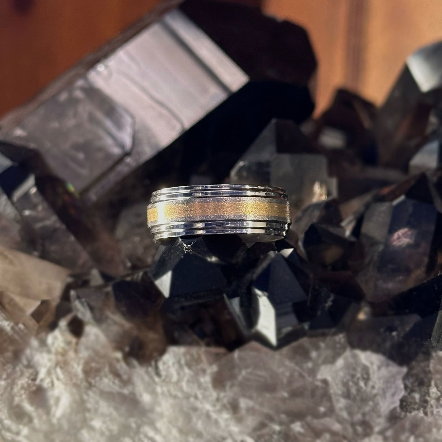 Photo of Titanium and Gold Double Edge Band in a decorative scene, designed by , available at Plumb Gold & Plumb Silver