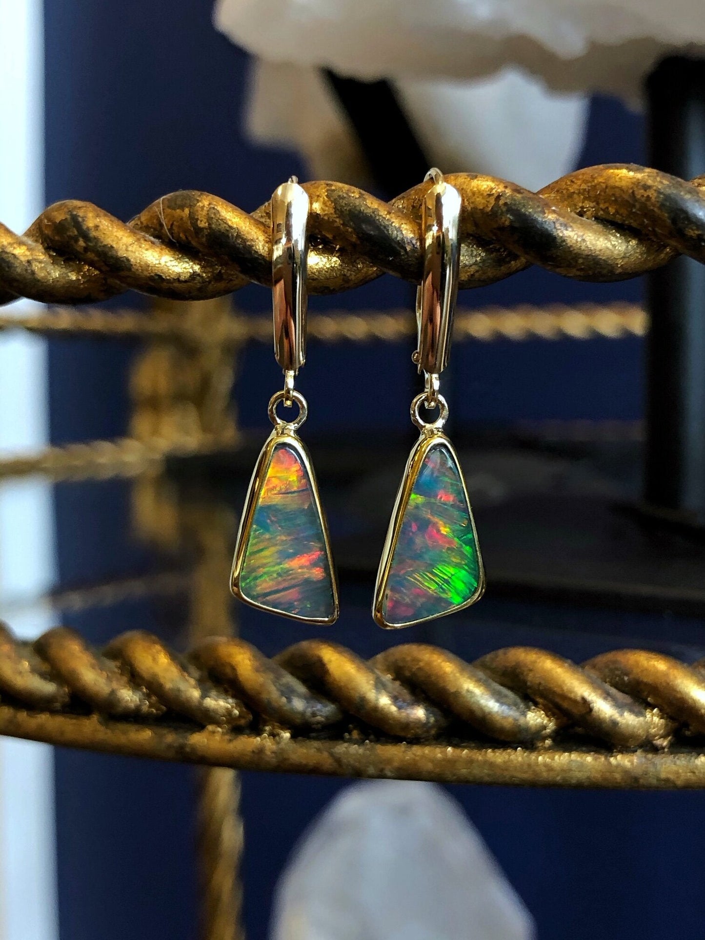 Photo of Trilliant Ethiopian Opal Dangles in a decorative scene, designed by , available at Plumb Gold & Plumb Silver