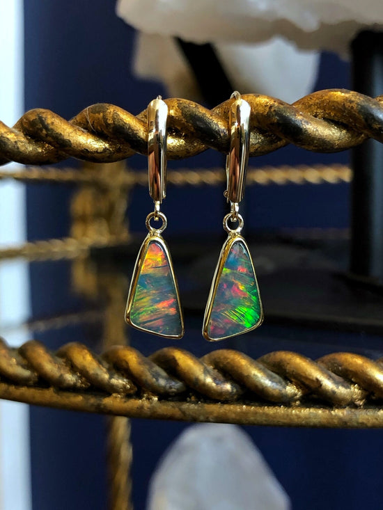 Photo of Trilliant Ethiopian Opal Dangles in a decorative scene, designed by , available at Plumb Gold & Plumb Silver