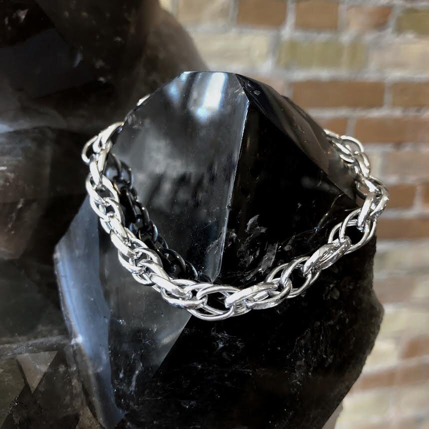 Photo of Triple Twist Bracelet in a decorative scene, designed by , available at Plumb Gold & Plumb Silver