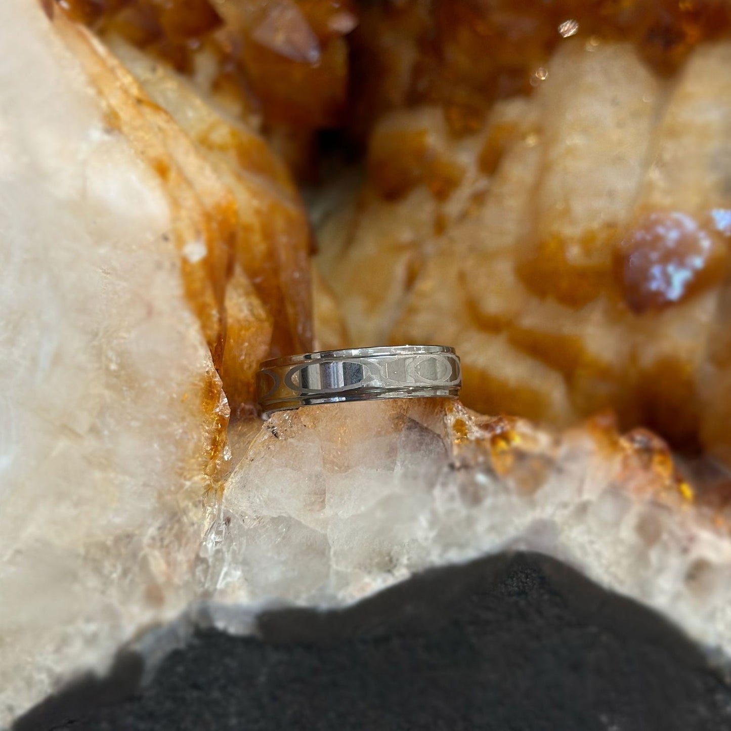 Photo of Tungsten Etched Band in a decorative scene, designed by , available at Plumb Gold & Plumb Silver