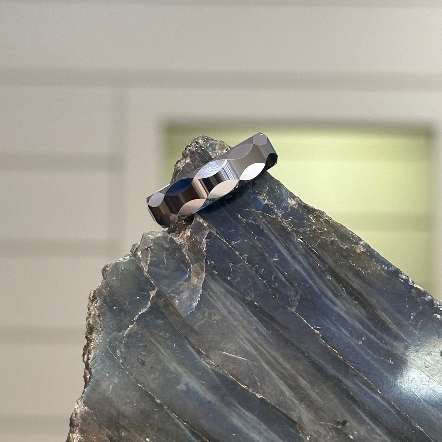 Photo of Tungsten Faceted Band in a decorative scene, designed by , available at Plumb Gold & Plumb Silver
