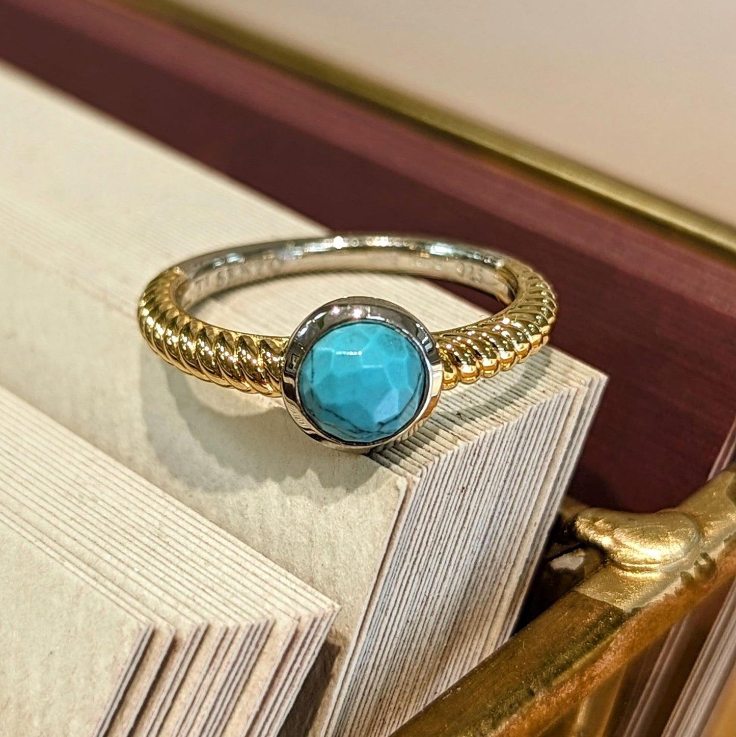 Photo of Turquoise Bezel Rope Ring in a decorative scene, designed by , available at Plumb Gold & Plumb Silver