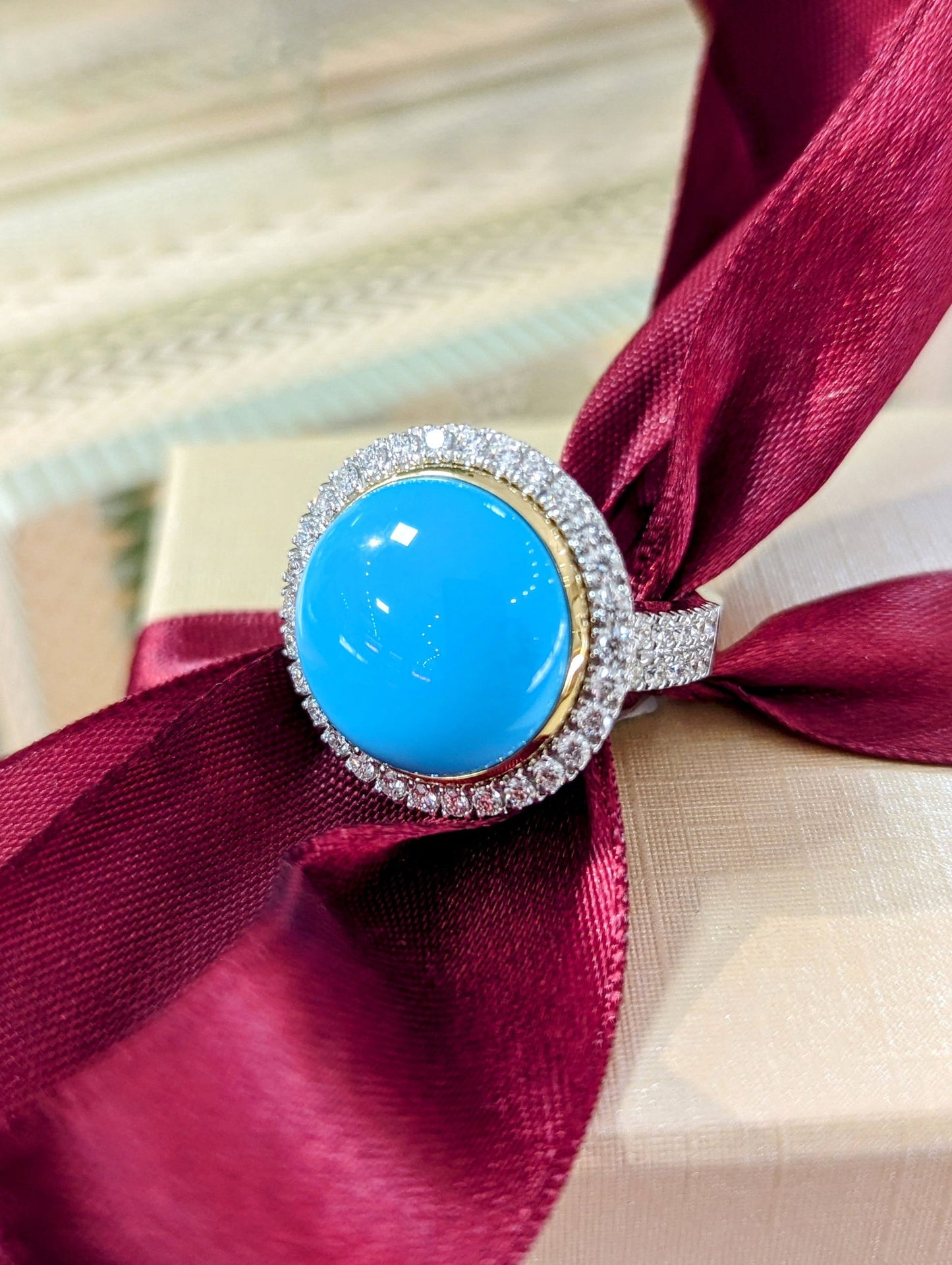 Photo of Turquoise and Diamond Halo Ring in a decorative scene, designed by , available at Plumb Gold & Plumb Silver