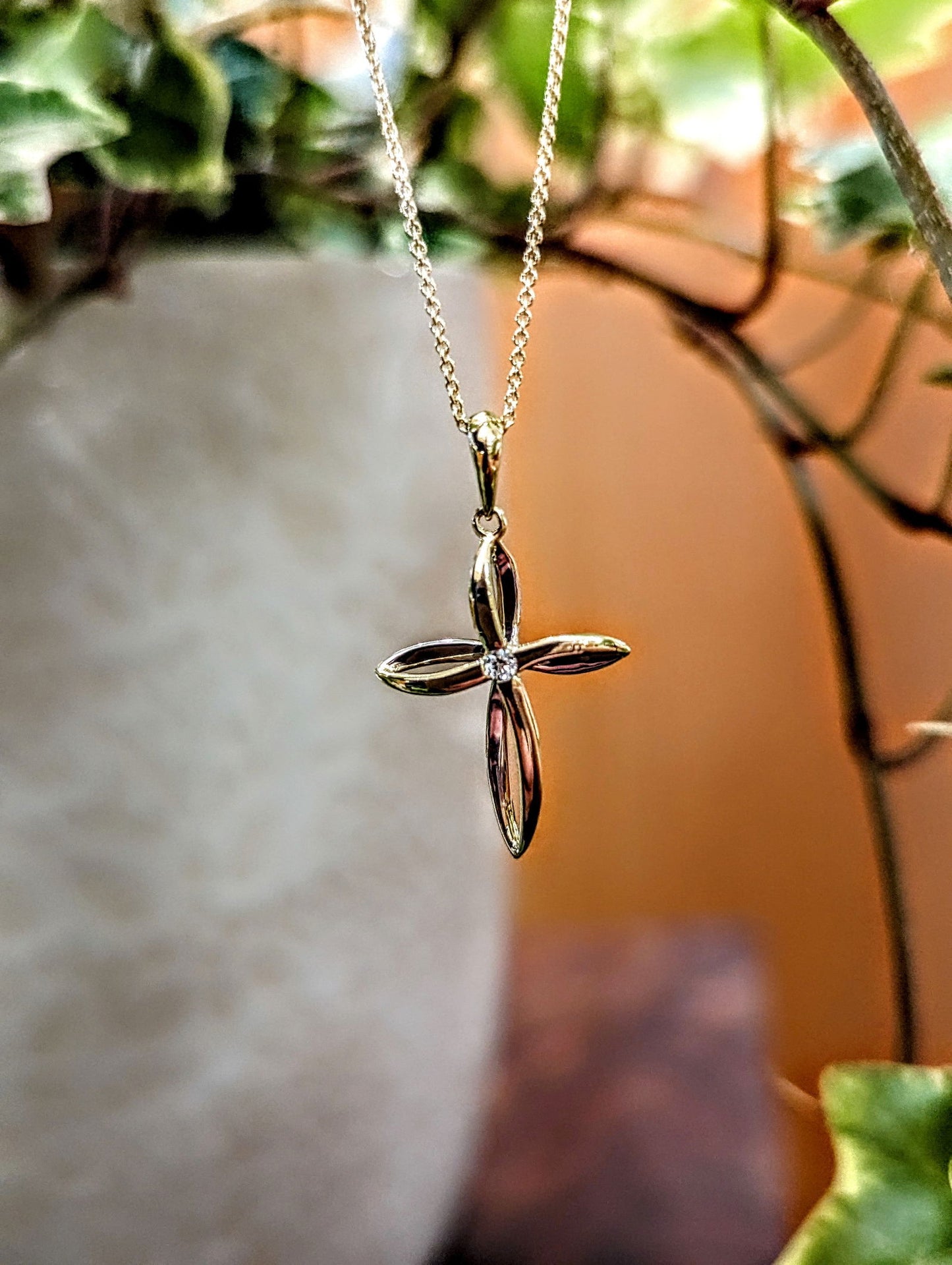 Photo of Twist Diamond Accented Cross in a decorative scene, designed by , available at Plumb Gold & Plumb Silver