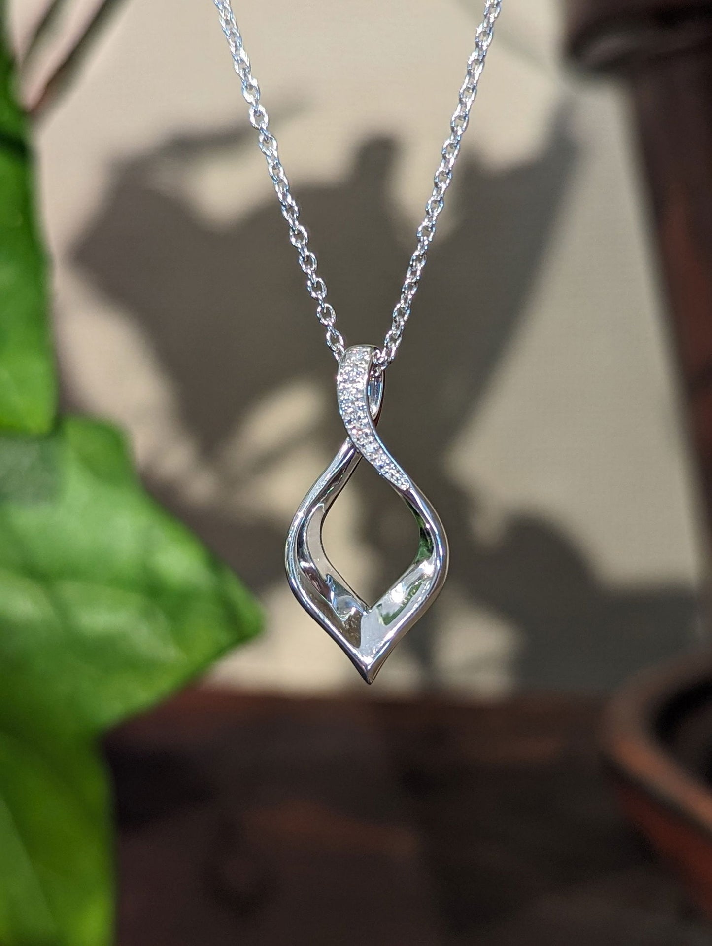 Photo of Twist Pendant with Diamond Accent in a decorative scene, designed by , available at Plumb Gold & Plumb Silver
