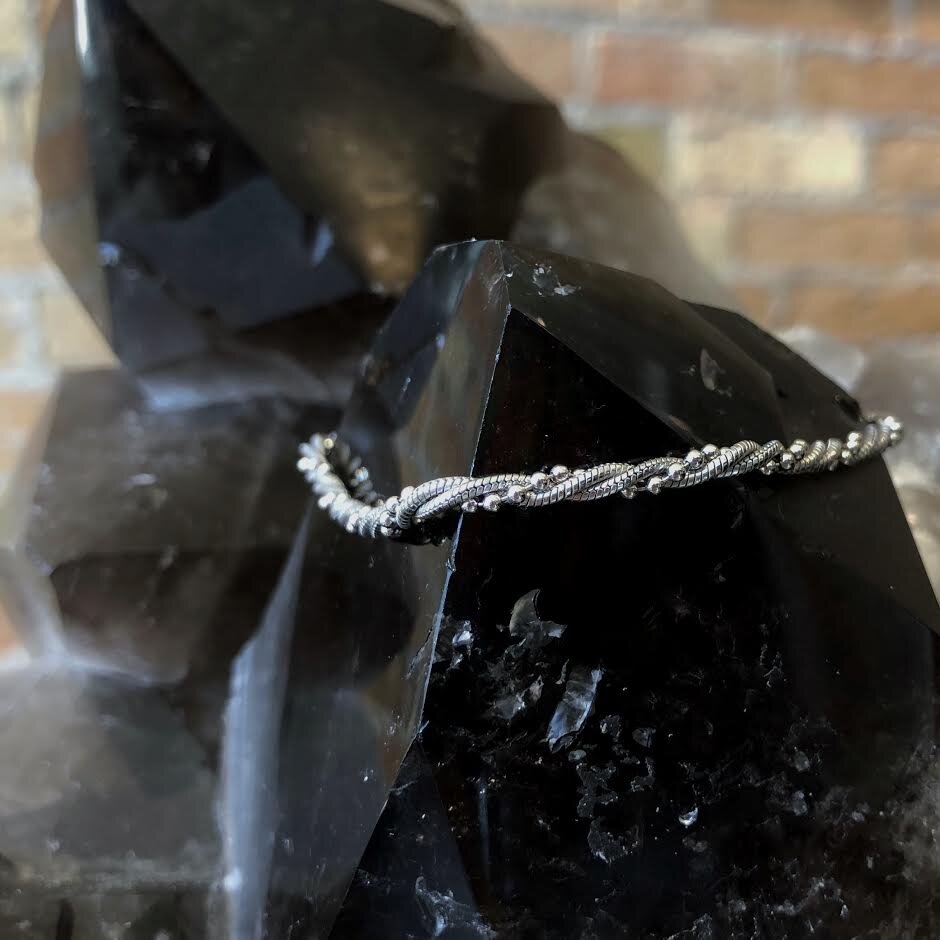 Photo of Twisted Bead Bracelet in a decorative scene, designed by , available at Plumb Gold & Plumb Silver