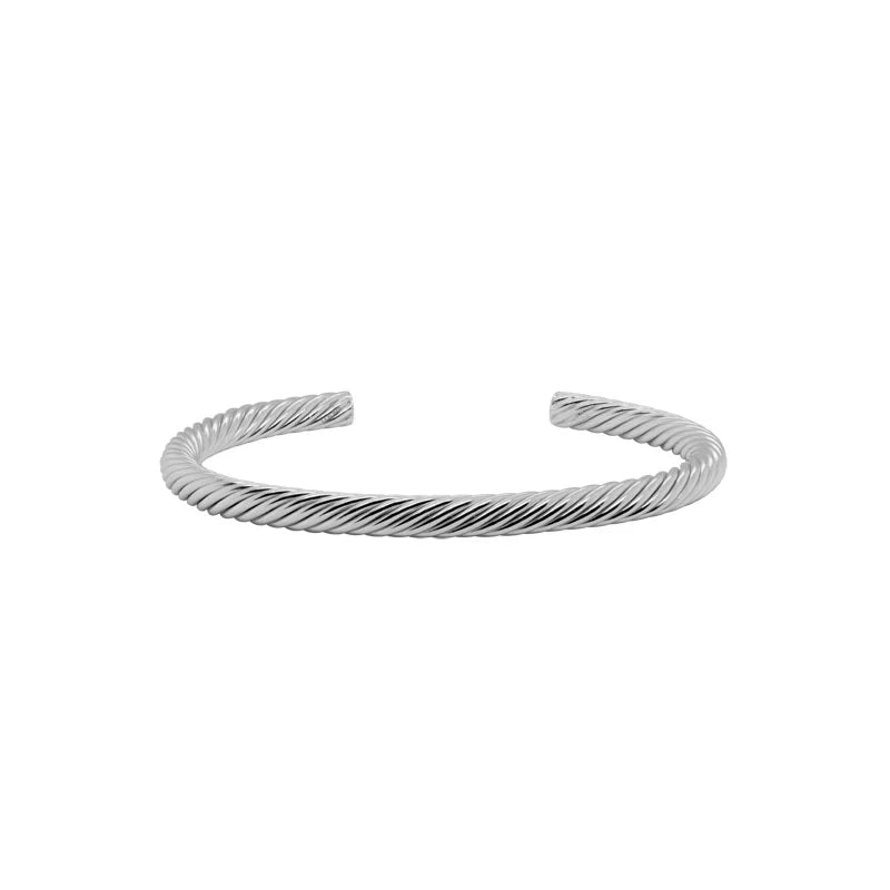 Photo of Twisted Cuff Bracelet in a decorative scene, designed by , available at Plumb Gold & Plumb Silver
