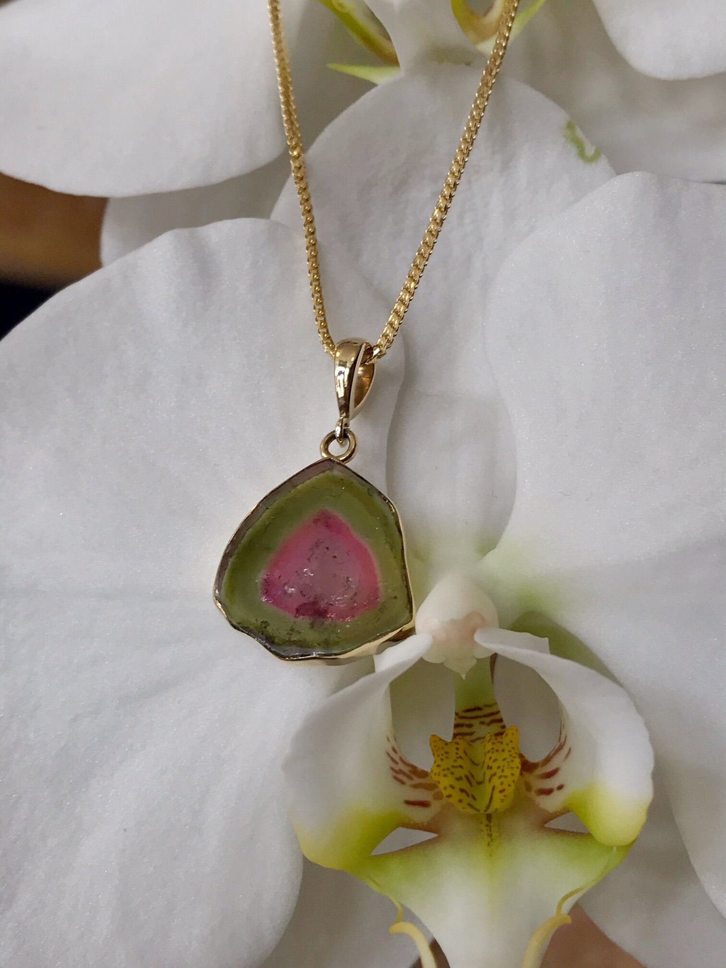 Photo of Watermelon Tourmaline Pendant in a decorative scene, designed by , available at Plumb Gold & Plumb Silver