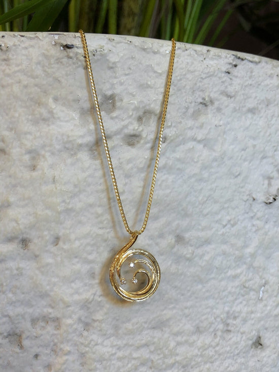 Photo of Wave Circle Pendant in a decorative scene, designed by , available at Plumb Gold & Plumb Silver