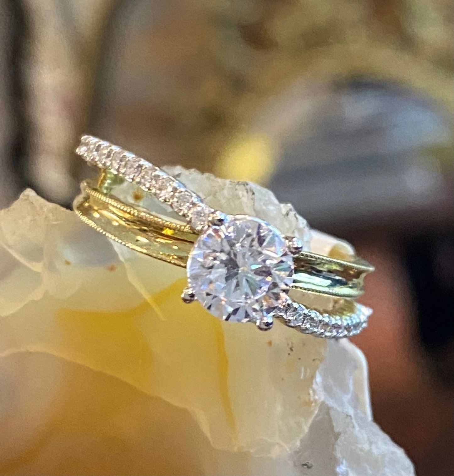 Photo of "Wave" Milgrain Concave Split Shank Engagement Ring in a decorative scene, designed by , available at Plumb Gold & Plumb Silver
