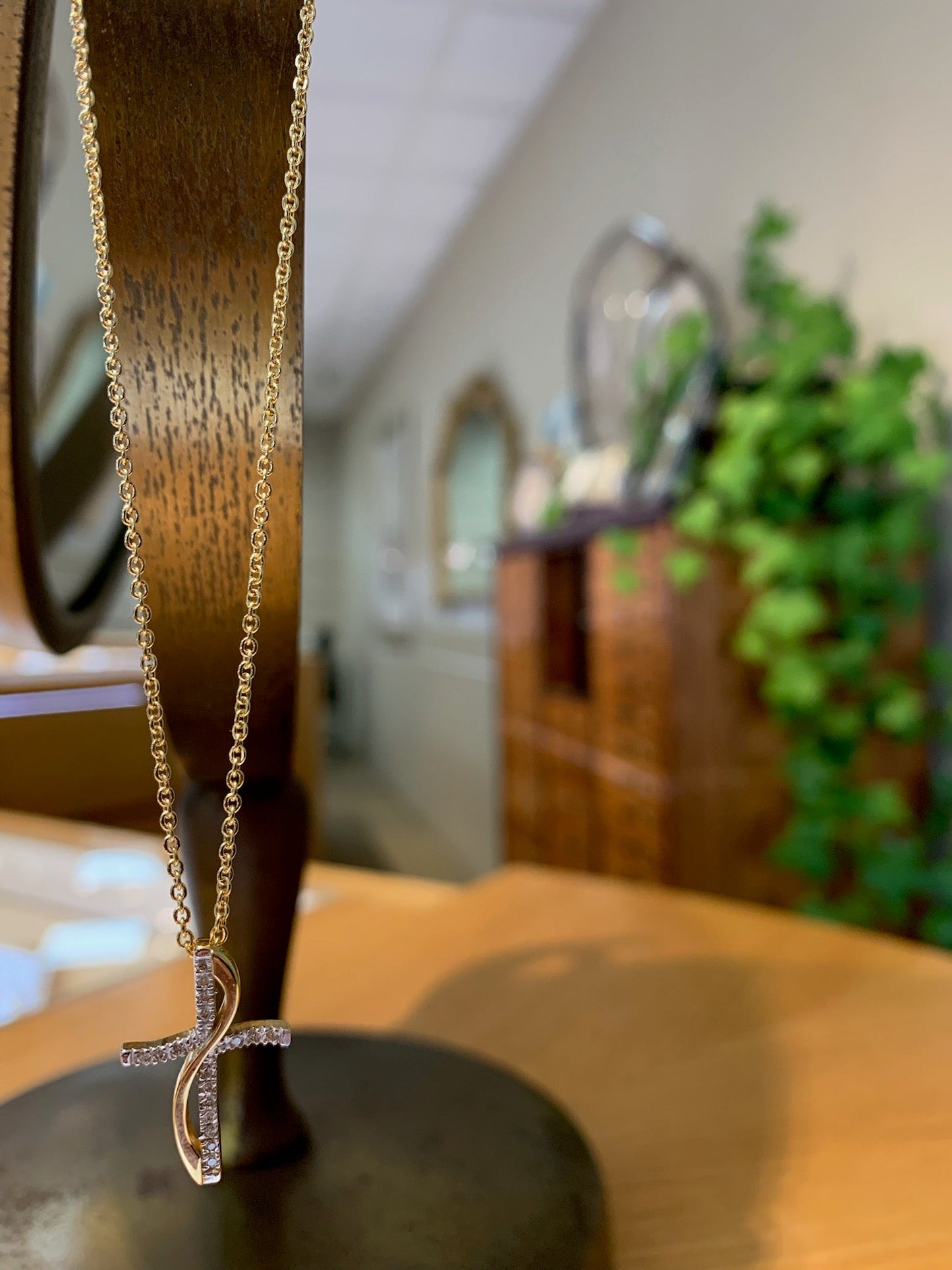 Photo of Wave Two-Tone Diamond Cross Necklace in a decorative scene, designed by , available at Plumb Gold & Plumb Silver