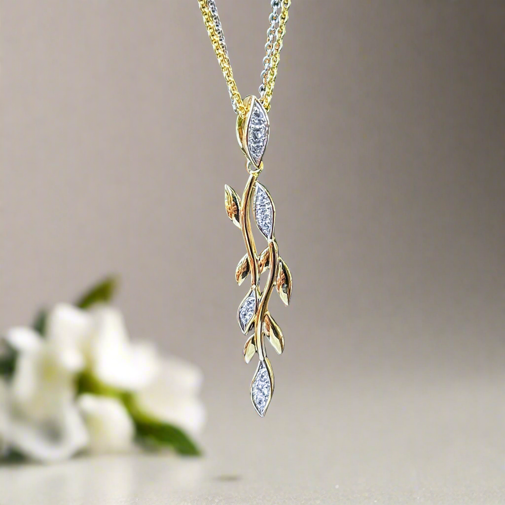 Photo of White Sapphire Vine Pendant in a decorative scene, designed by , available at Plumb Gold & Plumb Silver