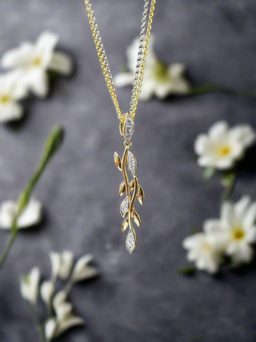 Photo of White Sapphire Vine Pendant in a decorative scene, designed by , available at Plumb Gold & Plumb Silver