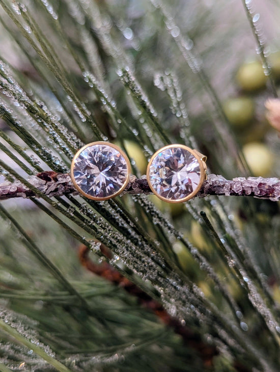 Photo of White Zircon Bezel Studs in a decorative scene, designed by , available at Plumb Gold & Plumb Silver