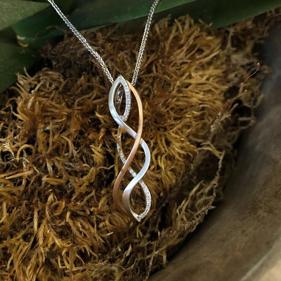 Photo of Woven Twist Diamond Pendant in a decorative scene, designed by , available at Plumb Gold & Plumb Silver