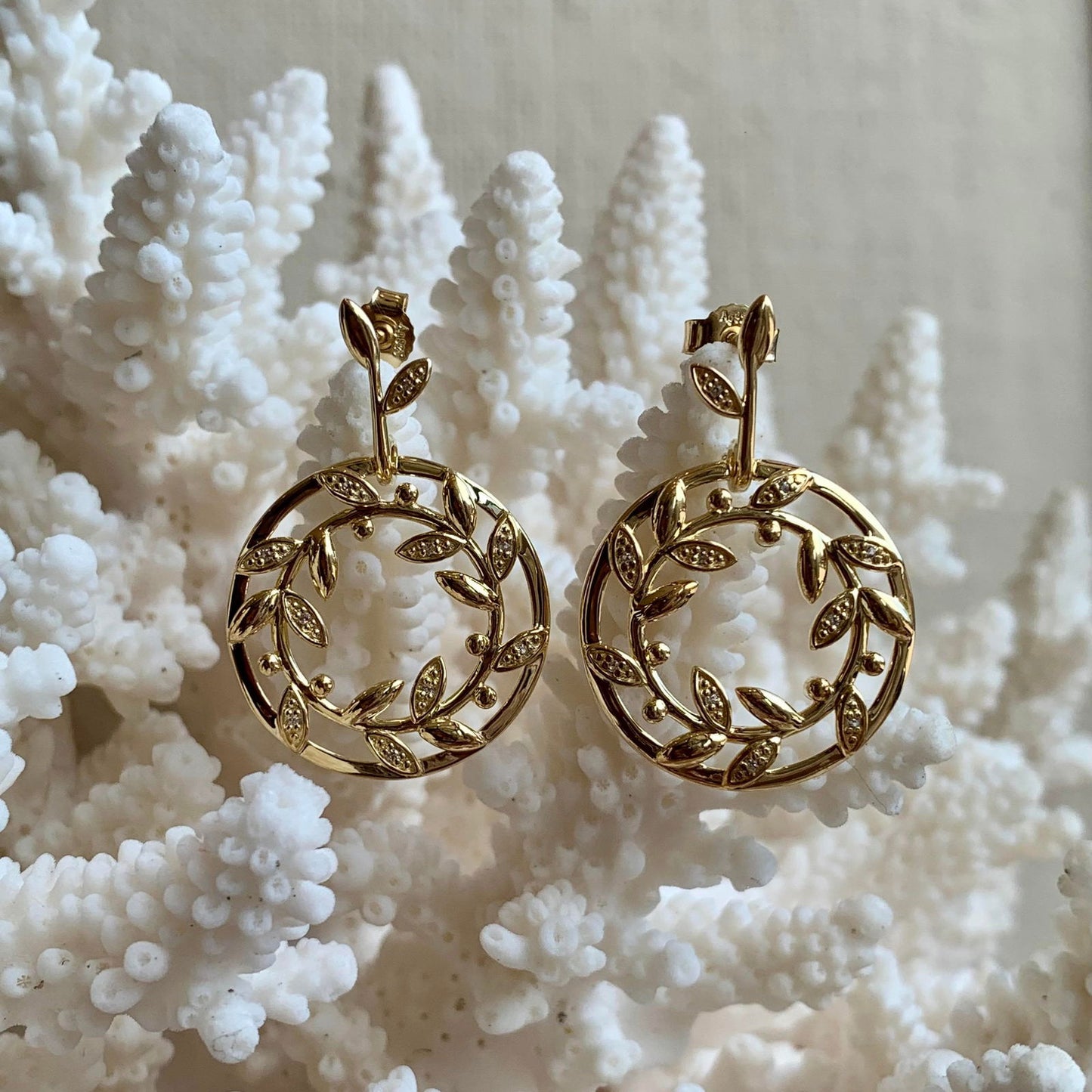 Photo of Wreath Earrings in a decorative scene, designed by , available at Plumb Gold & Plumb Silver
