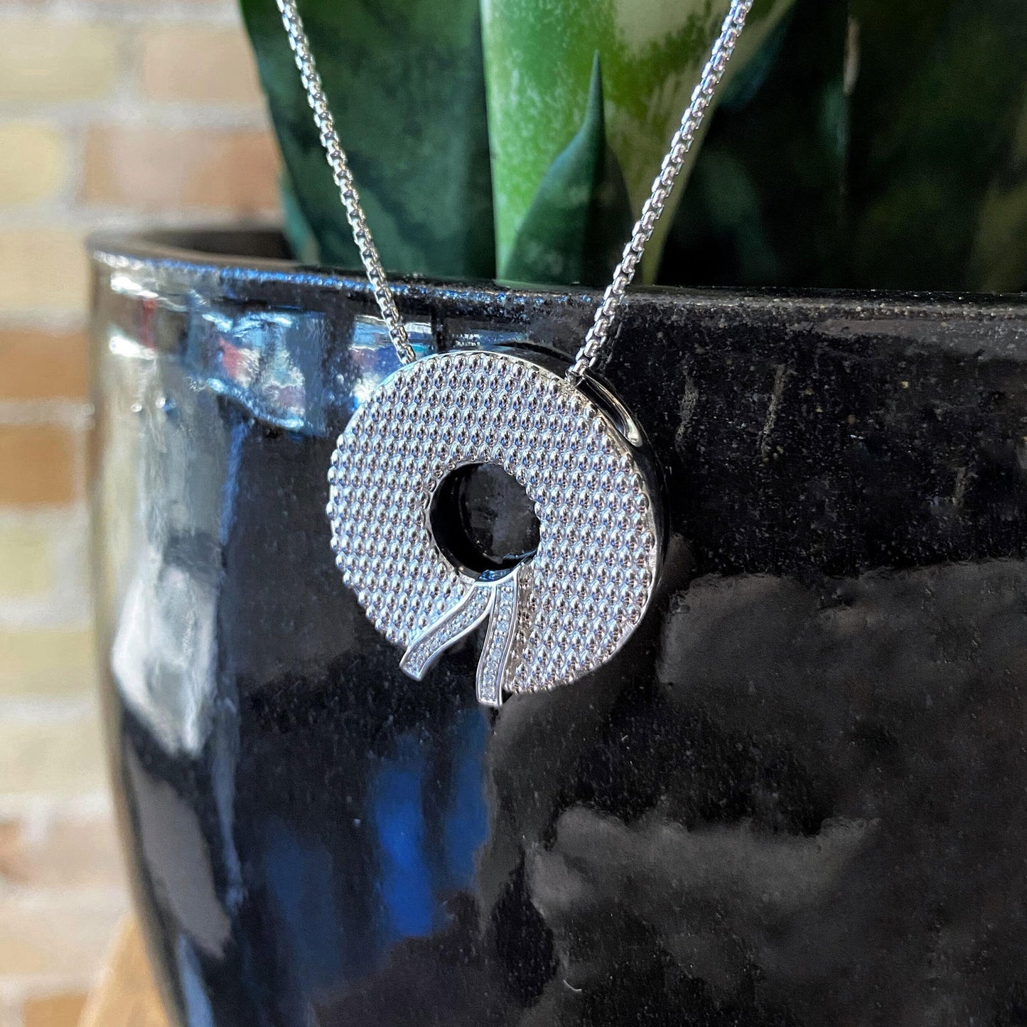 Photo of "Wreath" Pendant in a decorative scene, designed by , available at Plumb Gold & Plumb Silver
