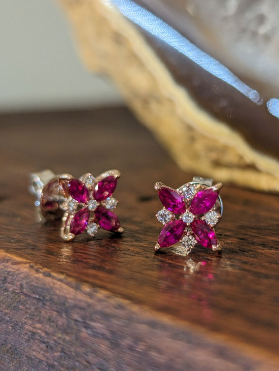 Photo of Zeghani Ruby Flower Stud Earrings in a decorative scene, designed by , available at Plumb Gold & Plumb Silver