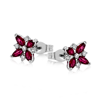 Photo of Zeghani Ruby Flower Stud Earrings in a decorative scene, designed by , available at Plumb Gold & Plumb Silver