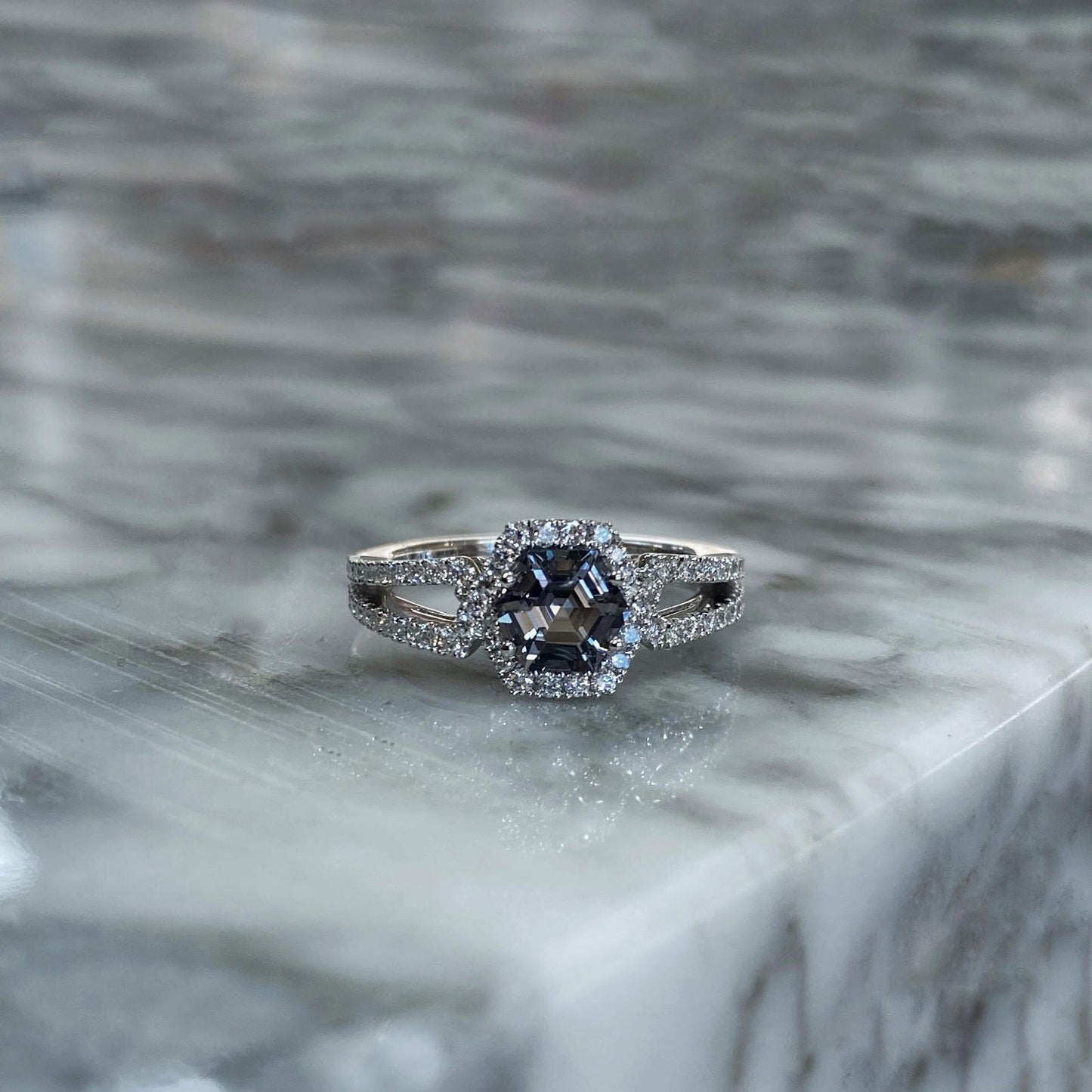 Photo of Zoma Color Grey Hexagon Ring in a decorative scene, designed by , available at Plumb Gold & Plumb Silver