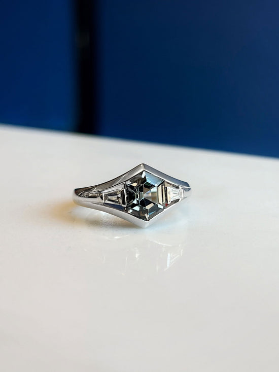 Photo of Zoma Color Grey Spinel Ring in a decorative scene, designed by , available at Plumb Gold & Plumb Silver