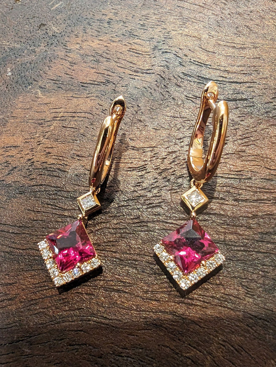 Photo of Zoma Color Rubellite and Diamond Dangle Earrings in a decorative scene, designed by , available at Plumb Gold & Plumb Silver