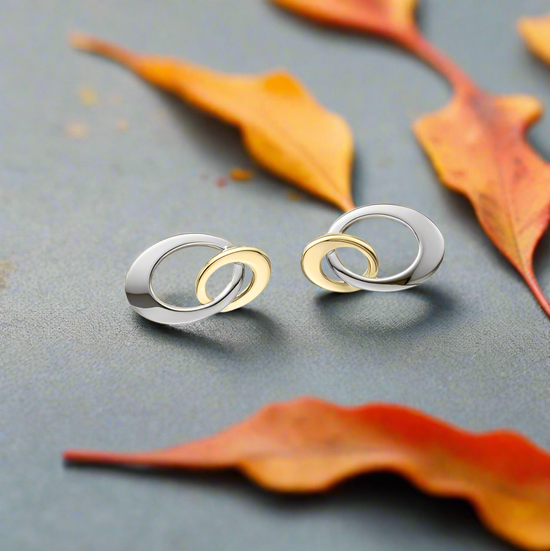 Stud earrings and a decorative scene with fall leaves, available at plumb silver jewelry store